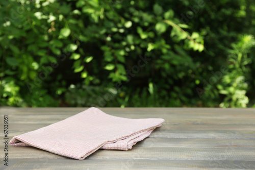 Wooden table with tablecloth, outdoors photo