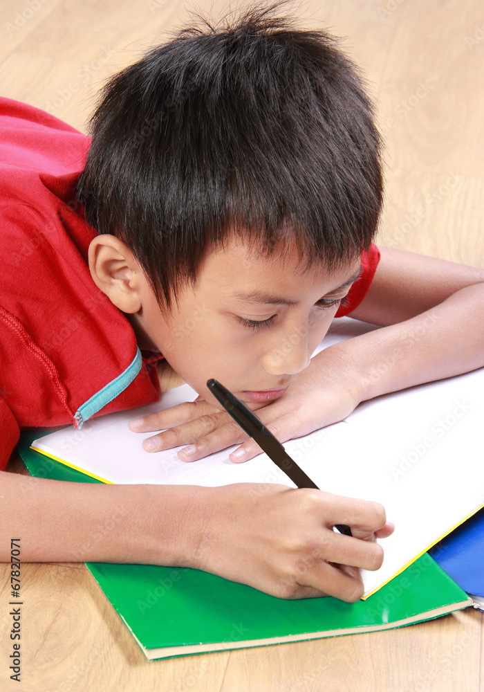 young boy writing something on the book young boy writing something on the book