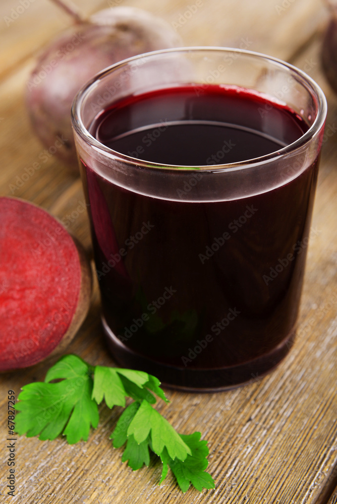 Glass of fresh beet juice and vegetables on wooden background Glass of fresh beet juice and vegetables on wooden background
