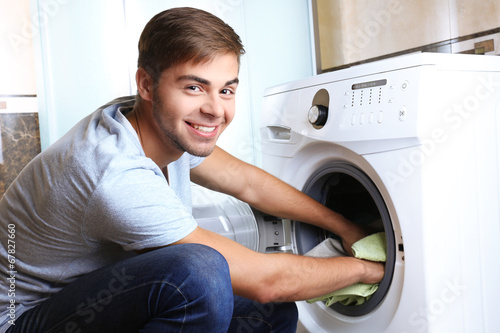 Housework: Man loading clothes into washing machine