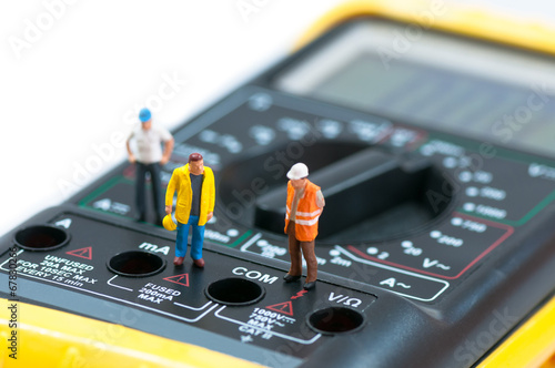 Fotografija Miniature workers on top of multimeter
