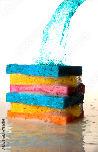 Mulit Colored Sponges Stacked on top of one another with Splash photo