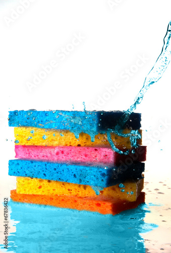 Mulit Colored Sponges Stacked on top of one another with Splash photo