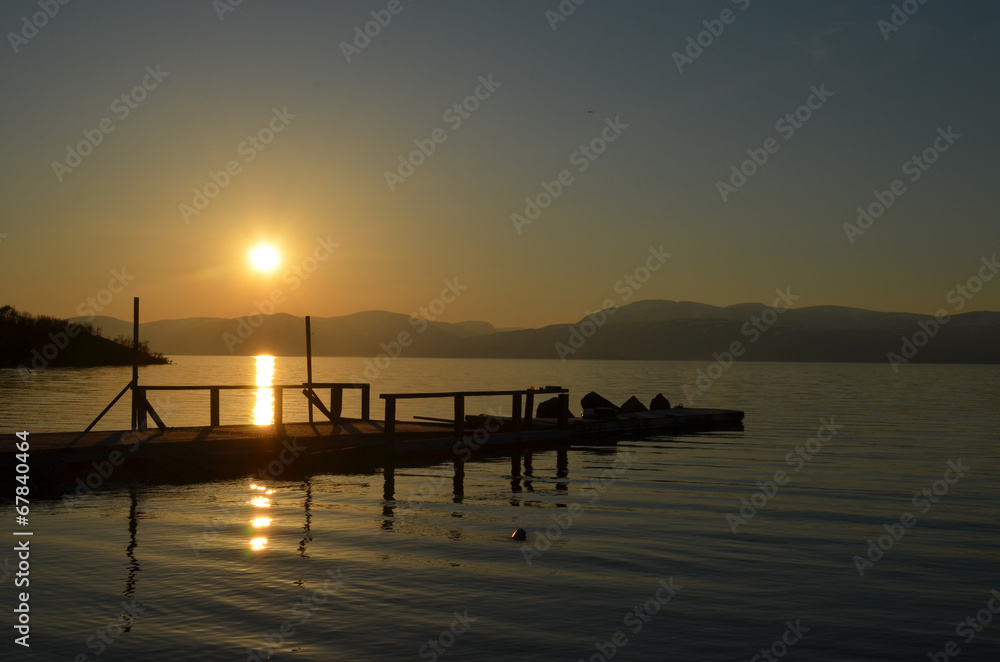 Midnight sun above pier in Lake Torneträsk