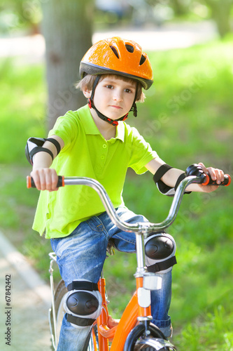 The young boy drives bike in park