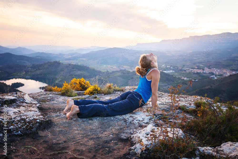 Naklejka premium Young Caucasian woman performing upward facing dog pose