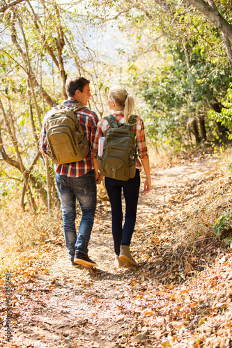 young couple walking in autumn forest