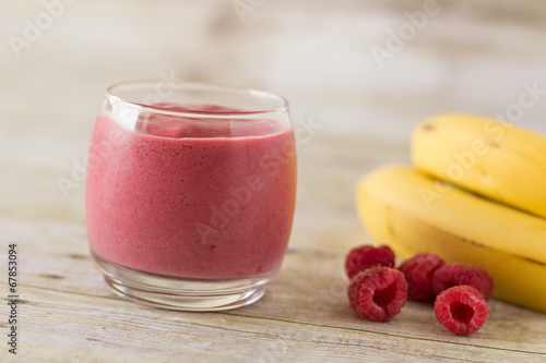 Banana Raspberry Smoothie in Clear Glass on Wood Backdrop
