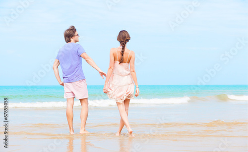 happy young couple in bright clothes and sunglasses having fun