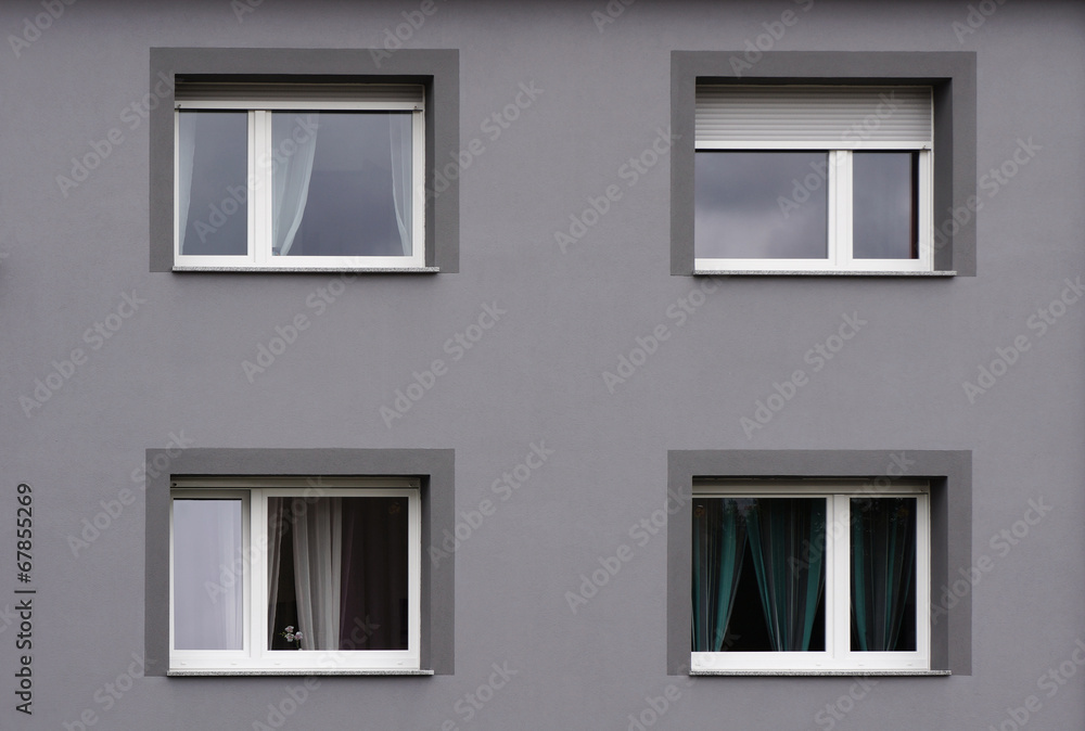 Modernisierte Fassade in grau mit vier Fenstern
