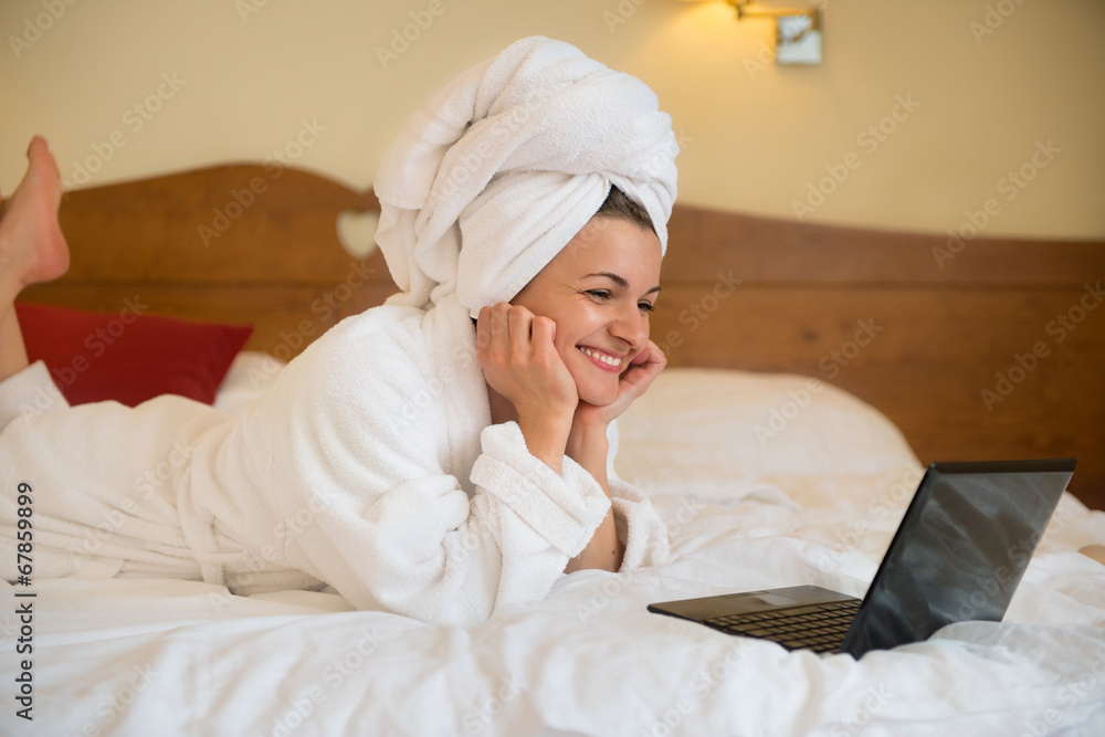 Beautiful woman in bathrobe with laptop Beautiful woman in bathrobe with laptop