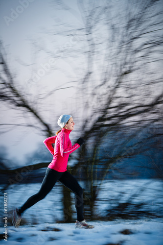 Winter running - Young woman running outdoors on a cold day