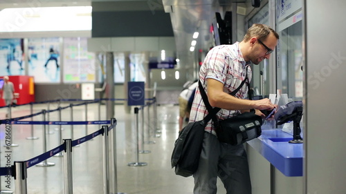 Man buying ticket at ticket office at train station