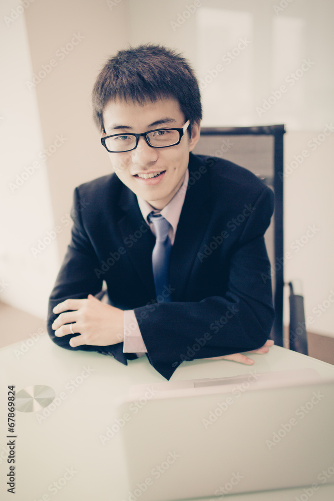 Young handsome man using laptop in his office Young handsome man using laptop in his office