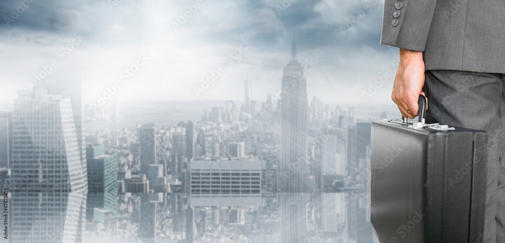 Composite image of businessman holding briefcase