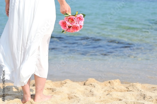 白いワンピースを着てピンクの花束を持って海に向かって立っている女性 Stock Photo Adobe Stock