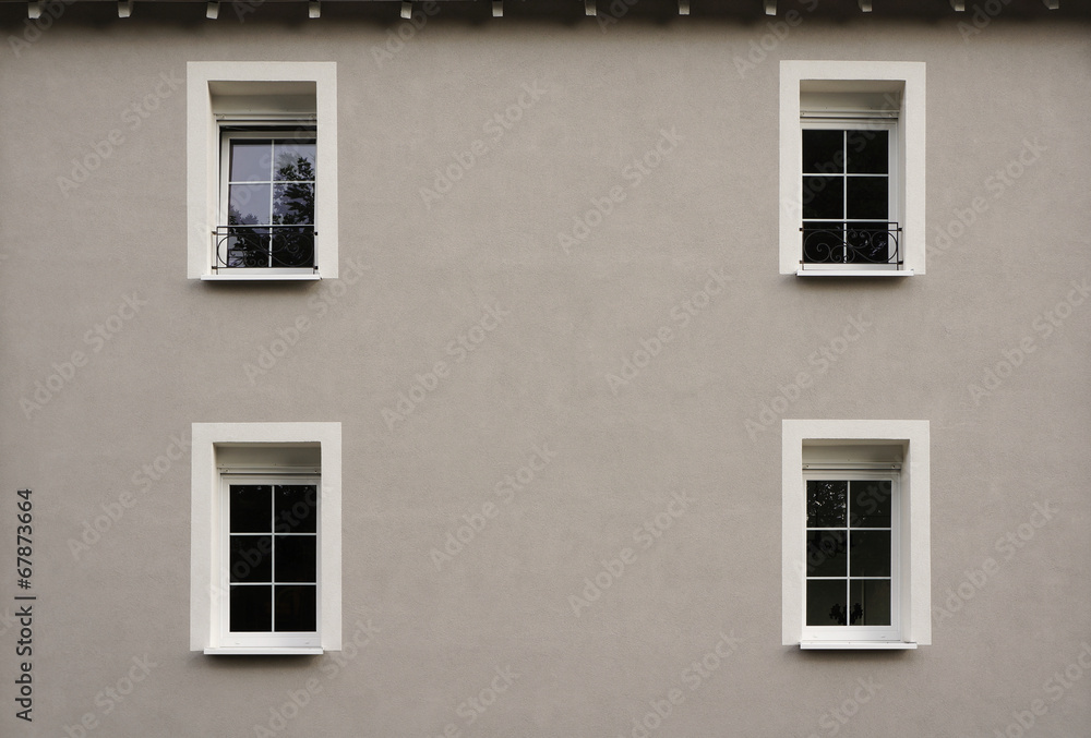 Modernisierte Fassade in grau mit vier Fenstern