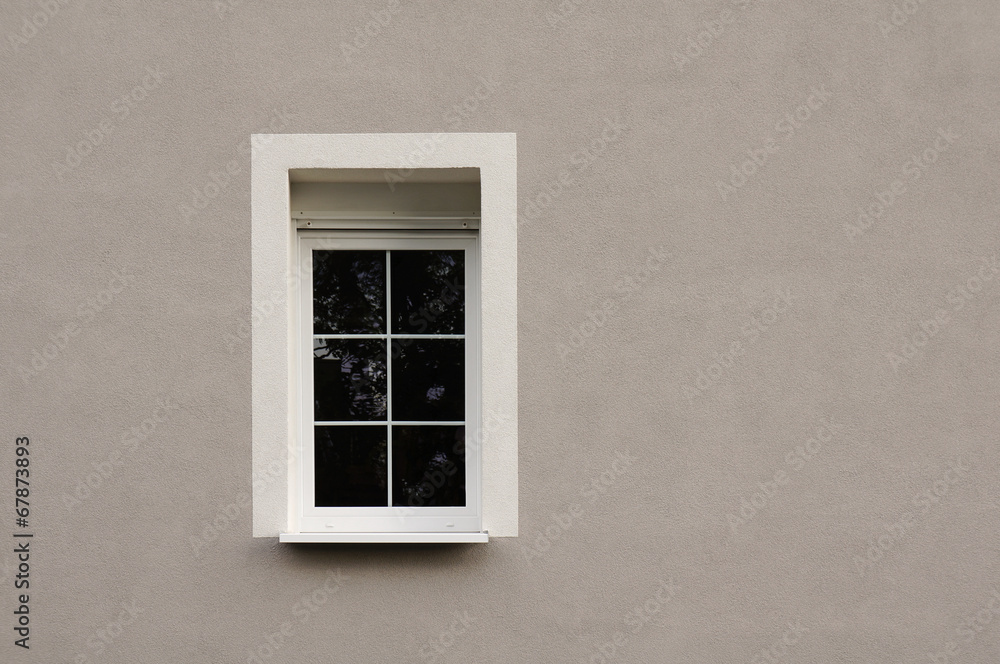 Modernisiertes Fenster mit Rolladen in grauer Fassade Modernisiertes Fenster mit Rolladen in grauer Fassade