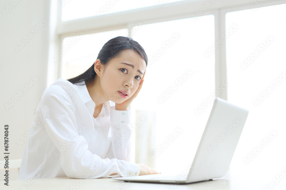 パソコンを前に困る若い女性