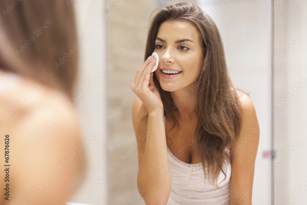 Beautiful brunette woman removing makeup from her face Beautiful brunette woman removing makeup from her face