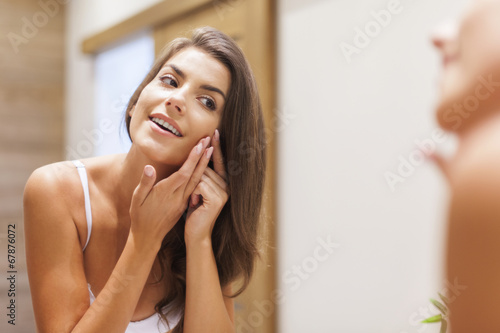 Woman removing pimple from her face photo