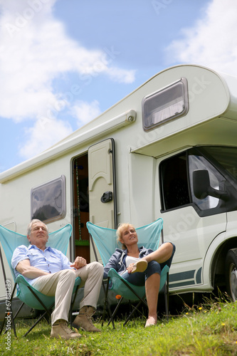Senior couple relaxing in camping folding chairs