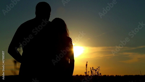 Man and woman in a field at sunset.Couple in love at sunset.