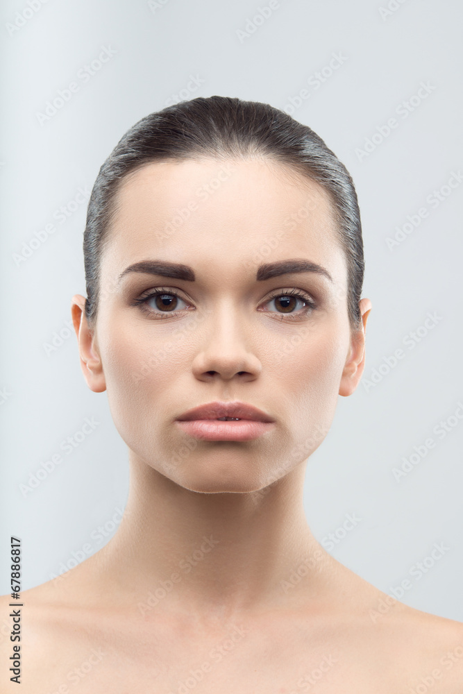 Portrait of beautiful young woman, isolated over grey background Portrait of beautiful young woman, isolated over grey background
