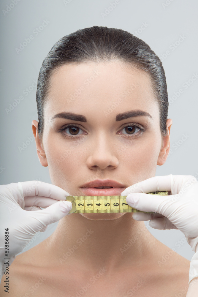 Woman head being measured by beautician hands Woman head being measured by beautician hands