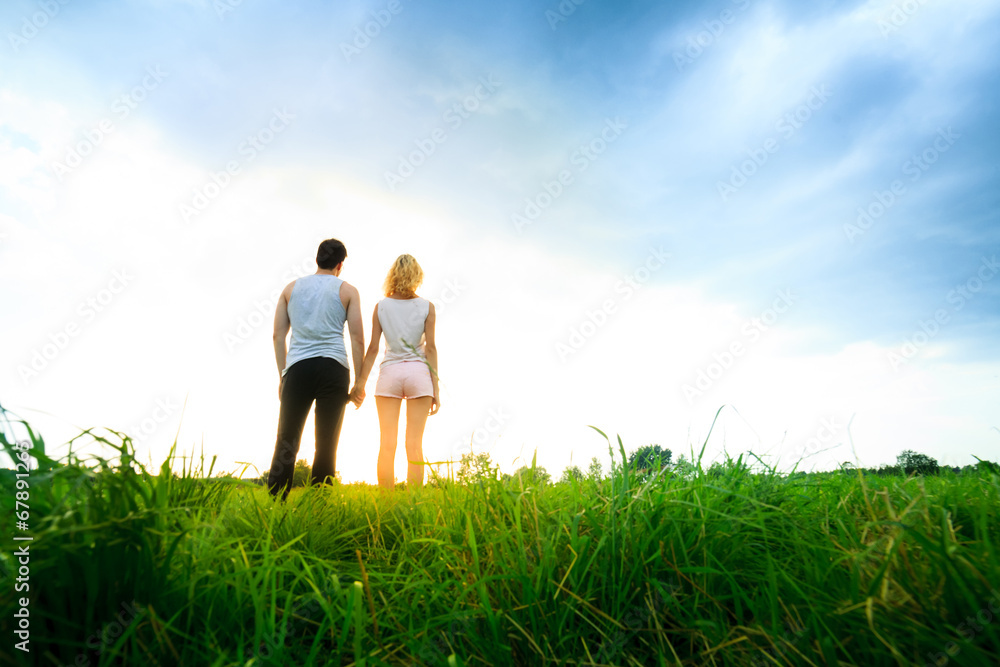 couple walking through the field and holding hands couple walking through the field and holding hands