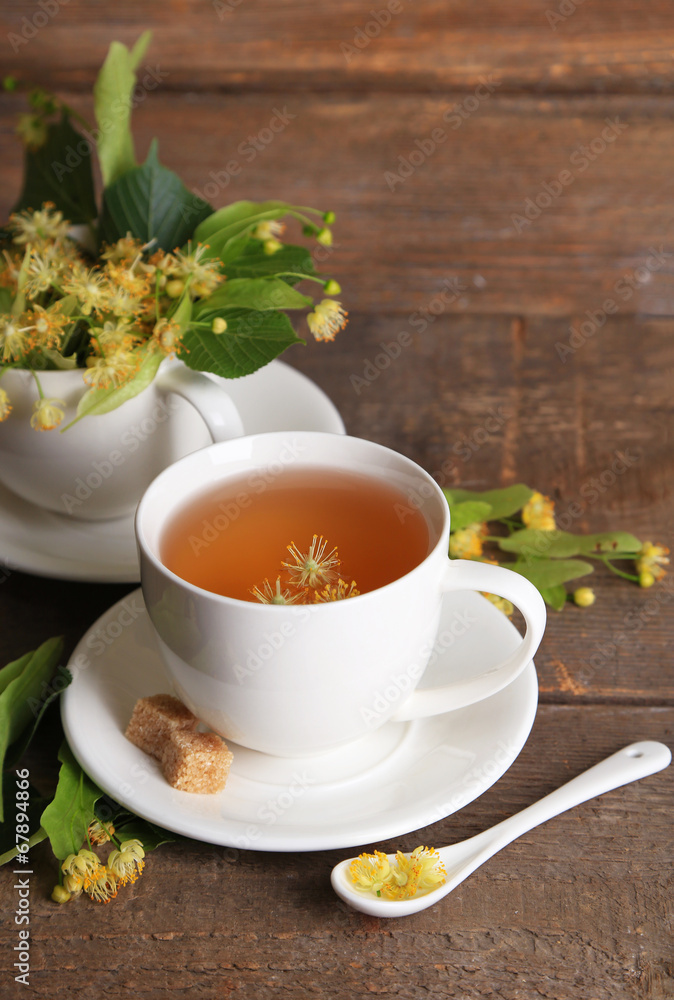 Tasty herbal tea with linden flowers on wooden table Tasty herbal tea with linden flowers on wooden table