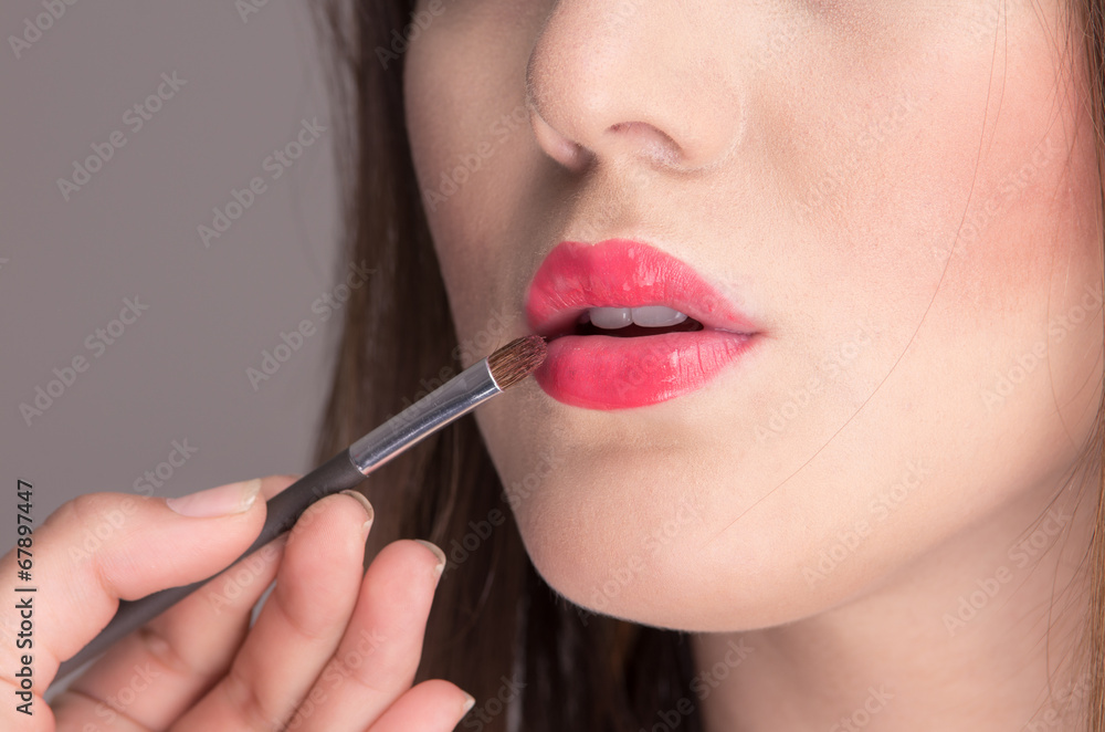 beautiful young woman applying makeup