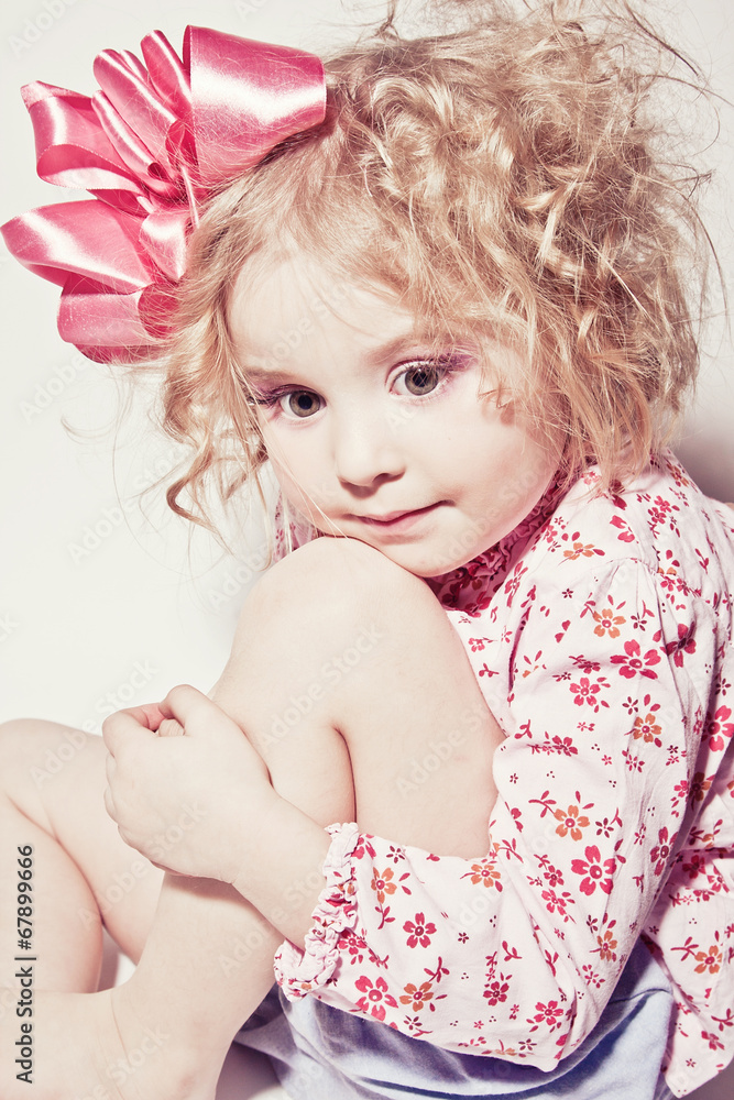 Beautiful young blond female child with curly hair posing in stu Beautiful young blond female child with curly hair posing in stu