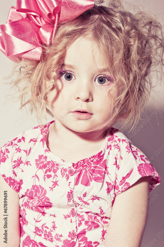 Beautiful young blond female child with curly hair posing in stu Beautiful young blond female child with curly hair posing in stu