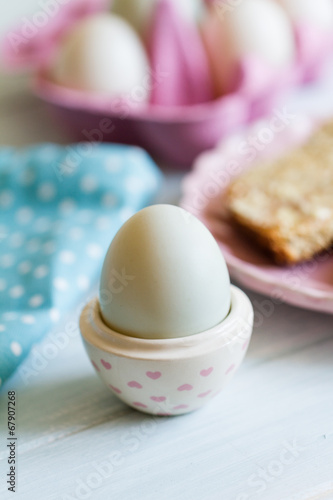 Blue duck egg in egg cup with pink hearts