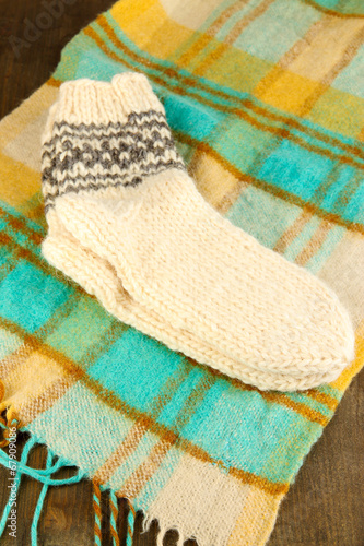 Warm knitted socks on plaid close-up