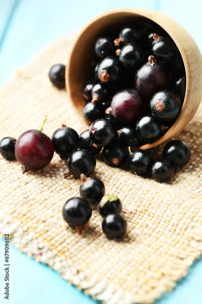 Ripe blackcurrants in bowl on wooden background. Ripe blackcurrants in bowl on wooden background.