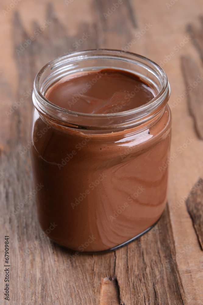 Sweet chocolate cream in jar on table close-up Sweet chocolate cream in jar on table close-up