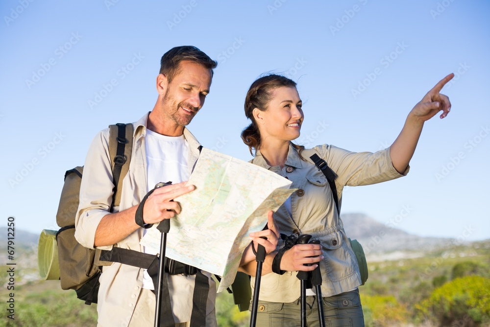Hiking couple consulting the map in the countryside Hiking couple consulting the map in the countryside
