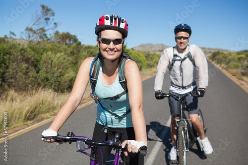 Fit happy couple going for a bike ride in the countryside