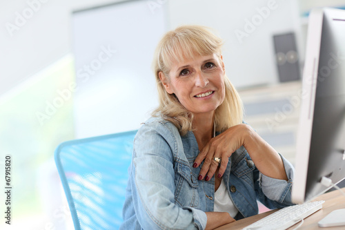 Senior woman in office working on desktop computer