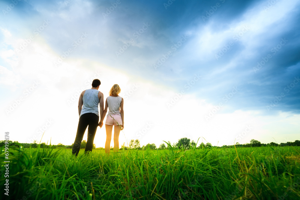 couple walking through the field and holding hands couple walking through the field and holding hands