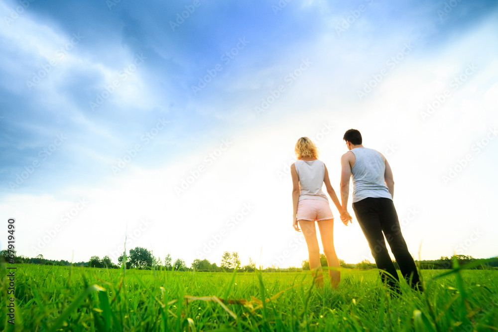 couple walking through the field and holding hands couple walking through the field and holding hands