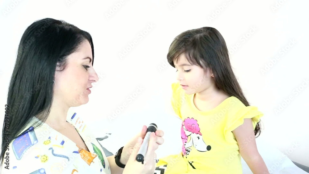 Female Pediatrician performing an eye exam on a female child Female Pediatrician performing an eye exam on a female child