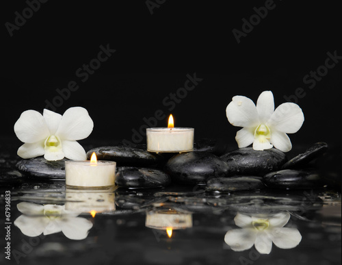 Two white orchid with white candle and therapy stones reflection