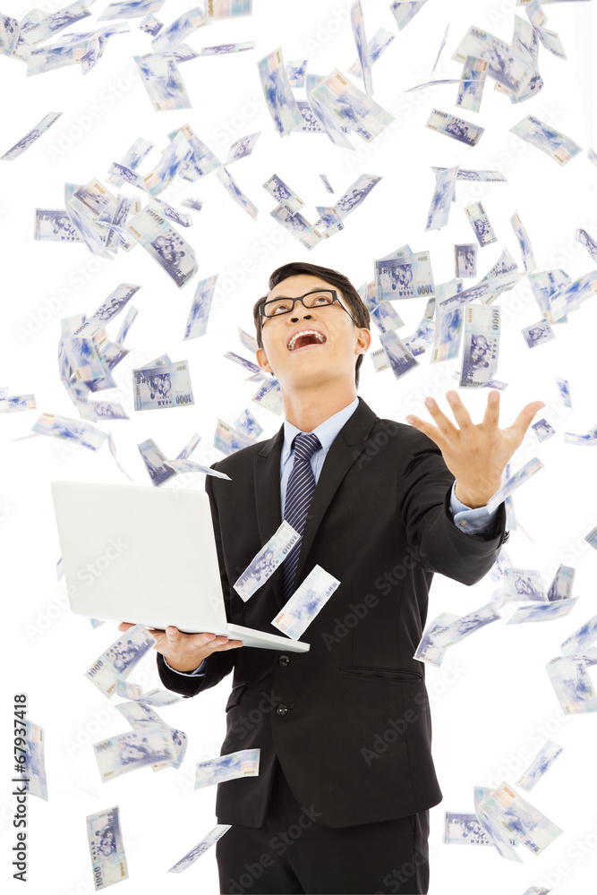 happy business man holding a laptop and catching money happy business man holding a laptop and catching money