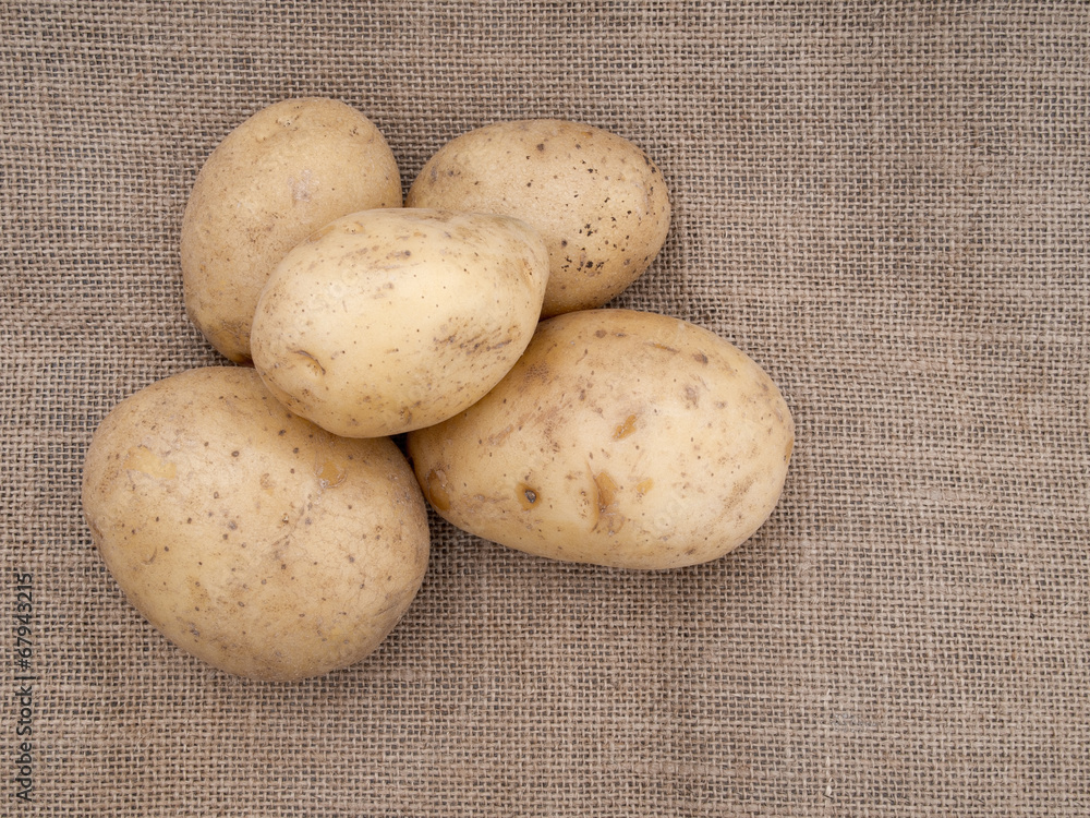 Potatoes on rustic hessian, burlap fabric background. Potatoes on rustic hessian, burlap fabric background.
