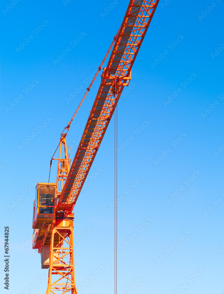 Hoisting crane. Fragment against the blue sky.