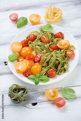 Boiled colored tagliatelle with roasted tomatoes