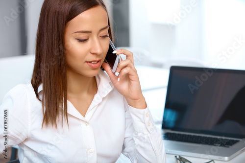 Businesswoman talking on mobile phone in a office